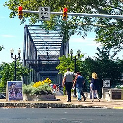 Pedestrians on bridge with red light in foreground